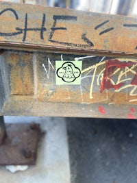 a rusty metal railing with graffiti on it
