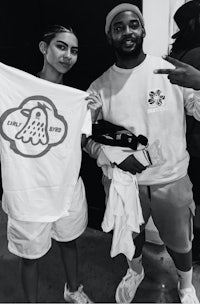 a black and white photo of a man and woman posing with a t - shirt