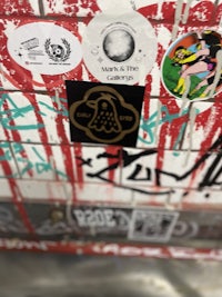 a wall covered in stickers and graffiti