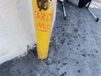 a yellow fire hydrant with graffiti on it