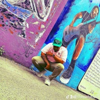 a man crouching down next to a wall