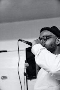 a black and white photo of a man singing into a microphone