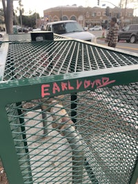 a green trash can with the word earlwood written on it